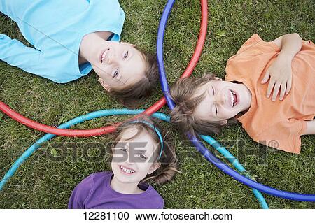 Stock Image - Children playing with hula hoops in a park; Toronto, Ontario, Canada. Fotosearch