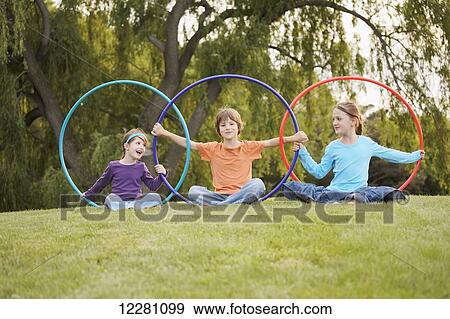 Children playing with hula hoops in a park; Toronto, Ontario, Canada View Large Photo Image Stock Photo - Children playing with hula hoops in a park; Toronto, Ontario, Canada. Fotosearch