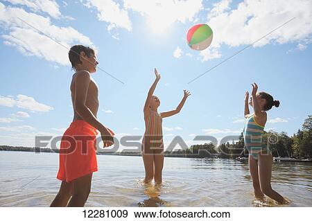 Children standing in lake playing with beach ball; Ontario, Canada View Large Photo Image Stock Photo - Children standing in lake playing with beach ball; Ontario, Canada. Fotosearch