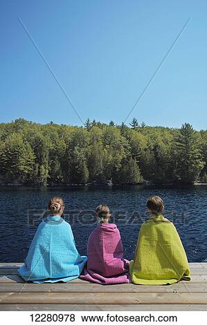 Children wrapped in towels sitting at end of dock on Crystal Lake; Ontario, Canada View Large Photo Image Stock Photo - Children wrapped in towels sitting at end of dock on Crystal Lake; Ontario, Canada. Fotosearch