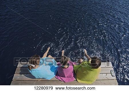 Children wrapped in towels sitting at end of dock on Crystal Lake; Ontario, Canada View Large Photo Image Stock Photo - Children wrapped in towels sitting at end of dock on Crystal Lake; Ontario, Canada. Fotosearch