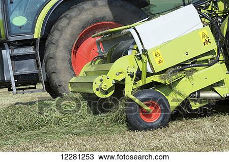 Stock Image - Close up of the pick up head of a Claas self propelled harvester making grass silage; United Kingdom. Fotosearch