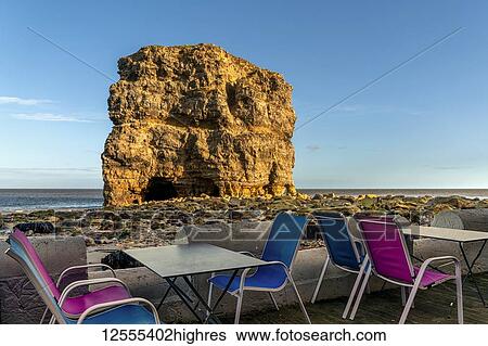 Colourful restaurant patio along the Atlantic coast with a large sea stack along the shore; South Shields, Tyne and Wear, England View Large Photo Image Stock Photograph - Colourful restaurant patio along the Atlantic coast with a large sea stack along the shore; South Shields, Tyne and Wear, England. Fotosearch