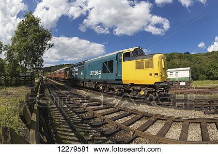 Stock Image - Colourful train engine of a passenger train on the tracks; Ainthorpe, North Yorkshire, England. Fotosearch