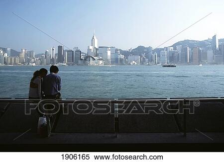 Stock Photography - Couple Waiting For Star Ferry Beside Harbor At Kowloon, Hong Kong, China. Fotosearch