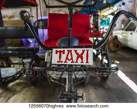 Stock Photograph - Cycle rickshaw with taxi sign; Havana, Cuba. Fotosearch