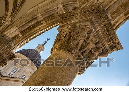 Stock Photograph - Detail of columns in the Rector's Palace facade and the Cathedral in the background; Dubrovnik, Dubrovnik-Neretva County, Croatia. Fotosearch