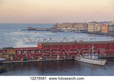 Stock Image - Early Morning view in the Port of Naples, Italy from the top deck of a cruise ship looking out to the Mediterranean Sea and the Naples navy base and ferry port; Naples, Campania, Italy. Fotosearch