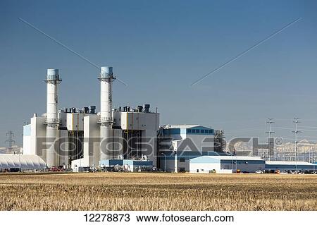 Electrical power generation plant in field with snow covered mountains in the background and blue sky; Alberta, Canada View Large Photo Image Stock Image - Electrical power generation plant in field with snow covered mountains in the background and blue sky; Alberta, Canada. Fotosearch