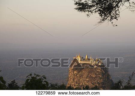 Stock Photo - Famous Taung Kalat Monastery near Mount Popa located on a volcanic plug and viewed at sunset from Mount Popa Resort; Myanmar. Fotosearch