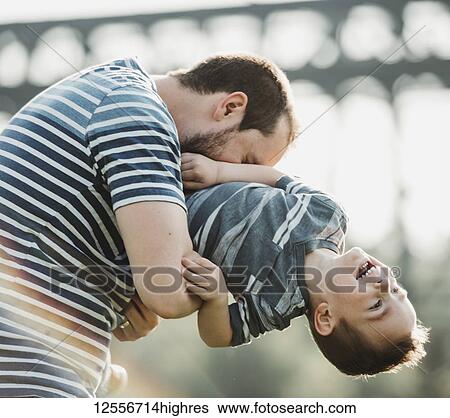 Stock Photograph - Father plays with his young son; Edmonton, Alberta, Canada. Fotosearch