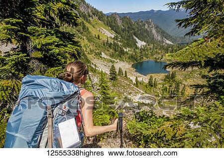 Female backpacker on High Divide Trail looking down at Round Lake in summertime, Seven Lakes Basin, Olympic National Park, Olympic Mountains; Washington, United States of America View Large Photo Image Stock Photograph - Female backpacker on High Divide Trail looking down at Round Lake in summertime, Seven Lakes Basin, Olympic National Park, Olympic Mountains; Washington, United States of America. Fotosearch