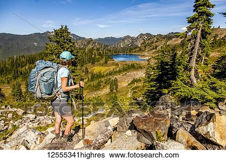 Female backpacker on High Divide Trail pausing to take a look at the view of Lunch Lake in summertime, Seven Lakes Basin, Olympic National Park, Olympic Mountains; Washington, United States of America View Large Photo Image Stock Photograph - Female backpacker on High Divide Trail pausing to take a look at the view of Lunch Lake in summertime, Seven Lakes Basin, Olympic National Park, Olympic Mountains; Washington, United States of America. Fotosearch