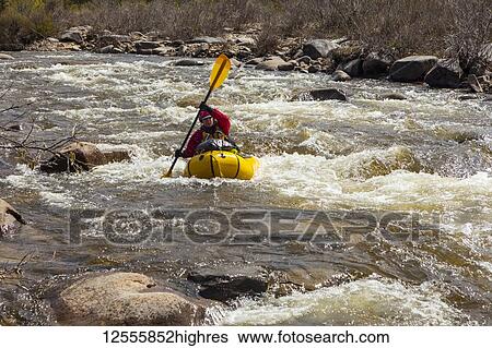 Female packrafter negotiating a technical rapid on the tributary of the Charley River with aufeis in summer; Alaska, United States of America View Large Photo Image Stock Photograph - Female packrafter negotiating a technical rapid on the tributary of the Charley River with aufeis in summer; Alaska, United States of America. Fotosearch