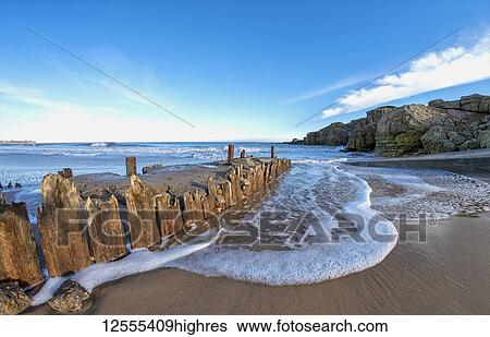 Stock Photograph - Foam and surf on a beach along the Atlantic coast; South Shields, Tyne and Wear, England. Fotosearch