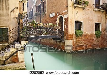 Footbridge with ornate railing and decorative plants crossing a canal; Venice, Italy View Large Photo Image Stock Image - Footbridge with ornate railing and decorative plants crossing a canal; Venice, Italy. Fotosearch