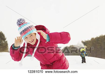 Stock Image - Girl and boy having snowball fight; King City, Ontario, Canada. Fotosearch