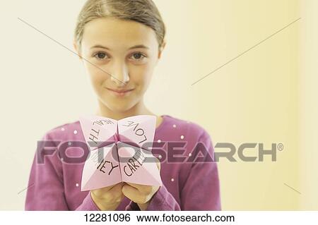 Stock Photograph - Girl holding paper fortune teller game; King City, Ontario, Canada. Fotosearch