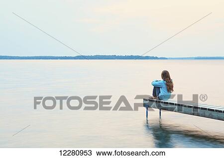 Girl sitting at end of dock at sunrise on Balsam Lake; Ontario, Canada View Large Photo Image Stock Image - Girl sitting at end of dock at sunrise on Balsam Lake; Ontario, Canada. Fotosearch