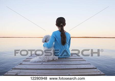 Girl sitting with her dog at end of dock on Balsam Lake; Ontario, Canada View Large Photo Image Stock Photo - Girl sitting with her dog at end of dock on Balsam Lake; Ontario, Canada. Fotosearch