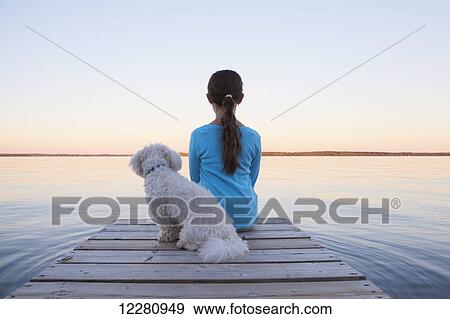 Girl sitting with her dog at end of dock on Balsam Lake; Ontario, Canada View Large Photo Image Stock Photo - Girl sitting with her dog at end of dock on Balsam Lake; Ontario, Canada. Fotosearch