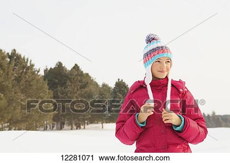Girl standing in snow holding hat tassels; King City, Ontario, Canada View Large Photo Image Stock Image - Girl standing in snow holding hat tassels; King City, Ontario, Canada. Fotosearch