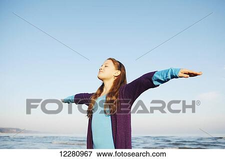 Girl standing on beach with arms spread; Toronto, Ontario, Canada View Large Photo Image Stock Photo - Girl standing on beach with arms spread; Toronto, Ontario, Canada. Fotosearch