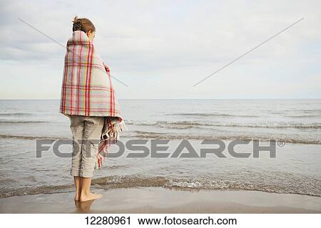 Girl standing on beach wrapped in blanket; Toronto, Ontario, Canada View Large Photo Image Stock Image - Girl standing on beach wrapped in blanket; Toronto, Ontario, Canada. Fotosearch