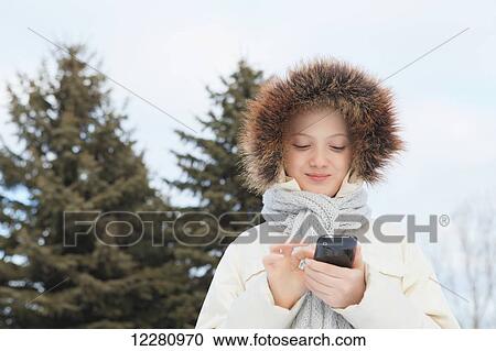 Girl texting on smart phone outdoors in winter; Toronto, Ontario, Canada View Large Photo Image Stock Image - Girl texting on smart phone outdoors in winter; Toronto, Ontario, Canada. Fotosearch