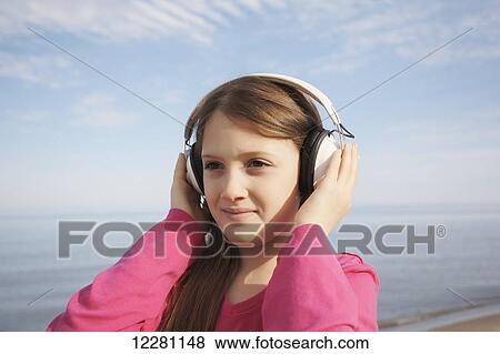 Stock Photo - Girl wearing headphones at a beach; Toronto, Ontario, Canada. Fotosearch