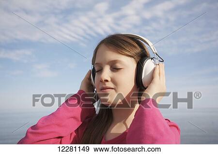 Stock Photo - Girl wearing headphones at a beach; Toronto, Ontario, Canada. Fotosearch