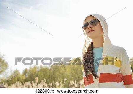 Stock Photography - Girl wearing sunglasses and hoodie in Bluffers Park; Scarborough, Ontario, Canada. Fotosearch