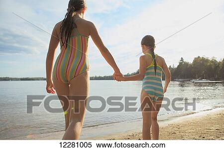 Girls holding hands walking to water on Crystal Lake; Ontario, Canada View Large Photo Image Stock Photography - Girls holding hands walking to water on Crystal Lake; Ontario, Canada. Fotosearch
