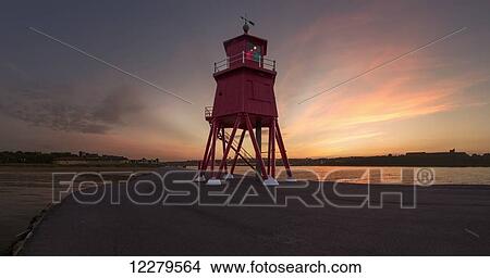 Picture - Herd Groyne Lighthouse on the water's edge of the River Tyne at sunset; South Shields, Tyne and Wear, England. Fotosearch