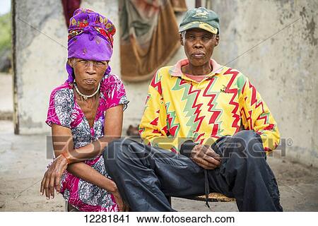 Husband and wife sitting together wearing bright, colourful clothing, San people; Ghanzi, Botswana View Large Photo Image Stock Image - Husband and wife sitting together wearing bright, colourful clothing, San people; Ghanzi, Botswana. Fotosearch