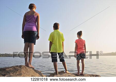 Kids standing on rock at edge of Crystal Lake; Ontario, Canada View Large Photo Image Stock Photo - Kids standing on rock at edge of Crystal Lake; Ontario, Canada. Fotosearch