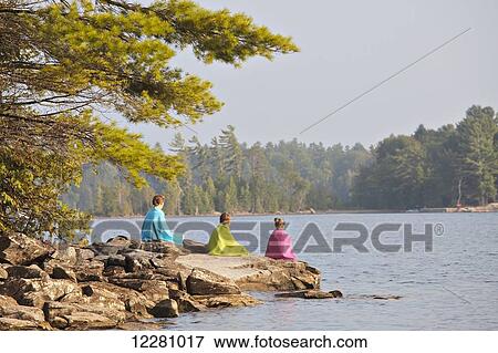 Kids wrapped in towels sitting on rock at edge of Crystal Lake; Ontario, Canada View Large Photo Image Stock Photo - Kids wrapped in towels sitting on rock at edge of Crystal Lake; Ontario, Canada. Fotosearch