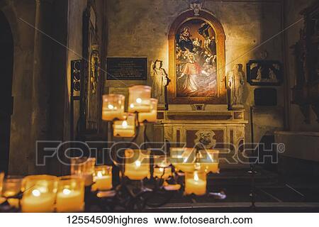Stock Photograph - Lit candles and artwork in a cathedral; Italy. Fotosearch