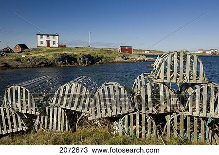 Stock Image - Lobster Traps And Traditional Saltbox House In Village Of Tilting, Fogo Island, Newfoundland & Labrador. Fotosearch