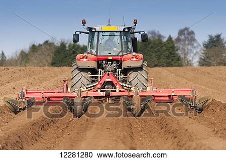 Stock Image - Making ridges for potato crop using a ridger pulled by a Massey Ferguson 7624; Yorkshire, England. Fotosearch