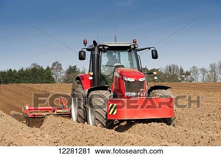 Stock Image - Making ridges for potato crop using a ridger pulled by a Massey Ferguson 7624; Yorkshire, England. Fotosearch