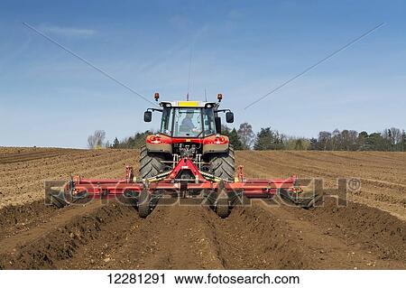 Stock Image - Making ridges for potato crop using a ridger pulled by a Massey Ferguson 7624; Yorkshire, England. Fotosearch