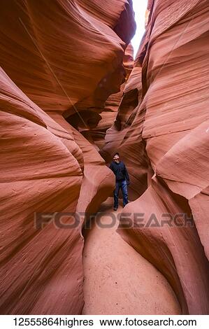 Stock Photograph - Man standing in a Slot Canyon known as Canyon X, near Page; Arizona, United States of America. Fotosearch
