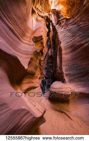 Stock Photograph - Man standing in a Slot Canyon known as Canyon X, near Page; Arizona, United States of America. Fotosearch
