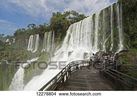 Metal walkway leading to Iguazu Falls, with a rainbow is visible over the water; Missiones, Argentina View Large Photo Image Picture - Metal walkway leading to Iguazu Falls, with a rainbow is visible over the water; Missiones, Argentina. Fotosearch