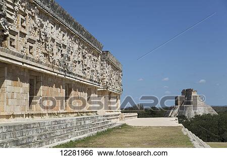Stock Photograph - Palace of the Governor (left), House of the Magician (background, right), Uxmal Mayan Archaeological site; Yucatan, Mexico. Fotosearch