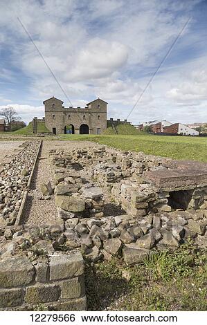 Stock Photograph - Pile of stones at Arbeia Roman Fort with buildings in the background; South Shields, Tyne and Wear, England. Fotosearch