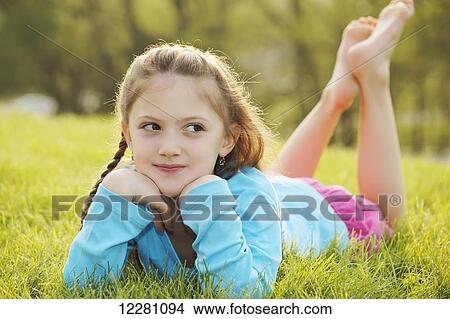 Portrait of girl laying down in grass; Toronto, Ontario, Canada View Large Photo Image Picture - Portrait of girl laying down in grass; Toronto, Ontario, Canada. Fotosearch