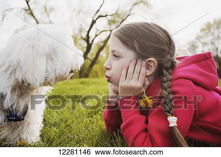 Stock Photograph - Portrait of young girl and puppy at a park; Toronto, Ontario, Canada. Fotosearch