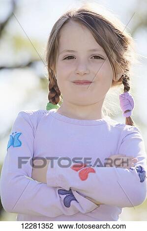 Stock Image - Portrait of young girl with arms crossed; Toronto, Ontario, Canada. Fotosearch